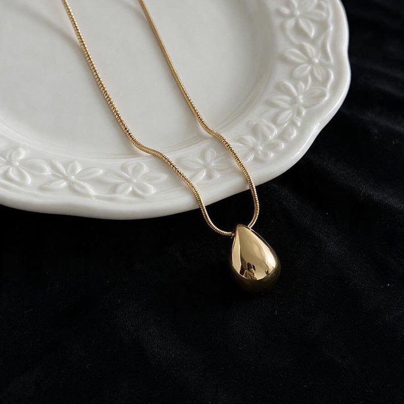 Aqua sculptural drop necklace worn at the neckline