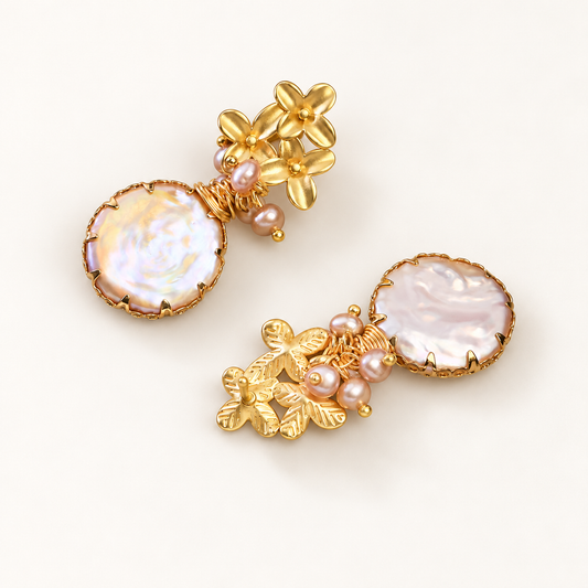 Flora baroque pearl drop earrings laid flat on a light surface