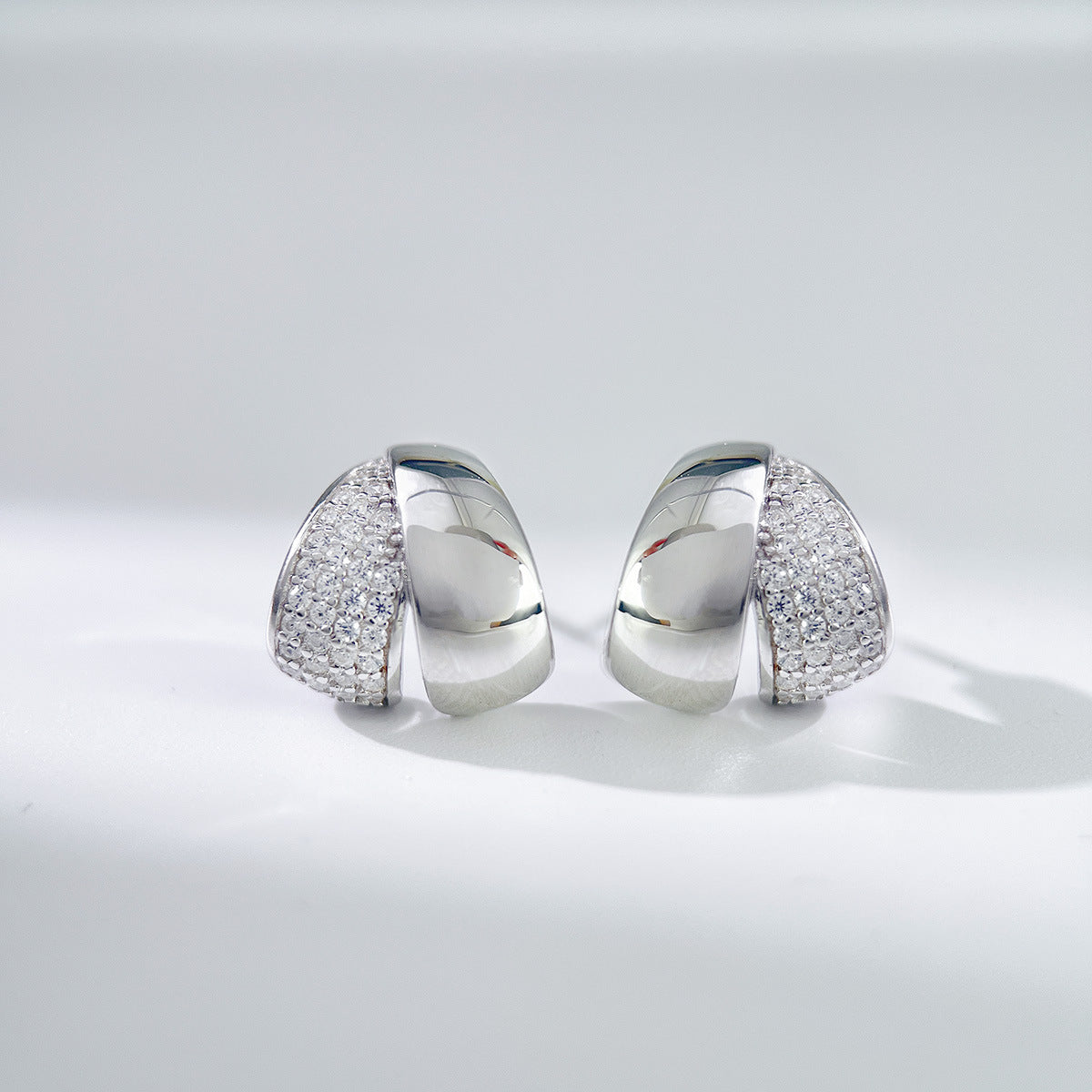 Polished sterling silver stud earrings with pavé zircon detailing