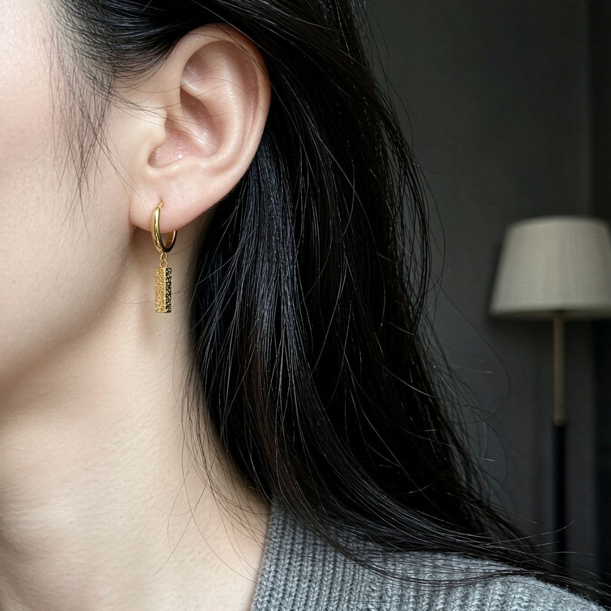 Model wearing a gold Sora hammered bar drop earring