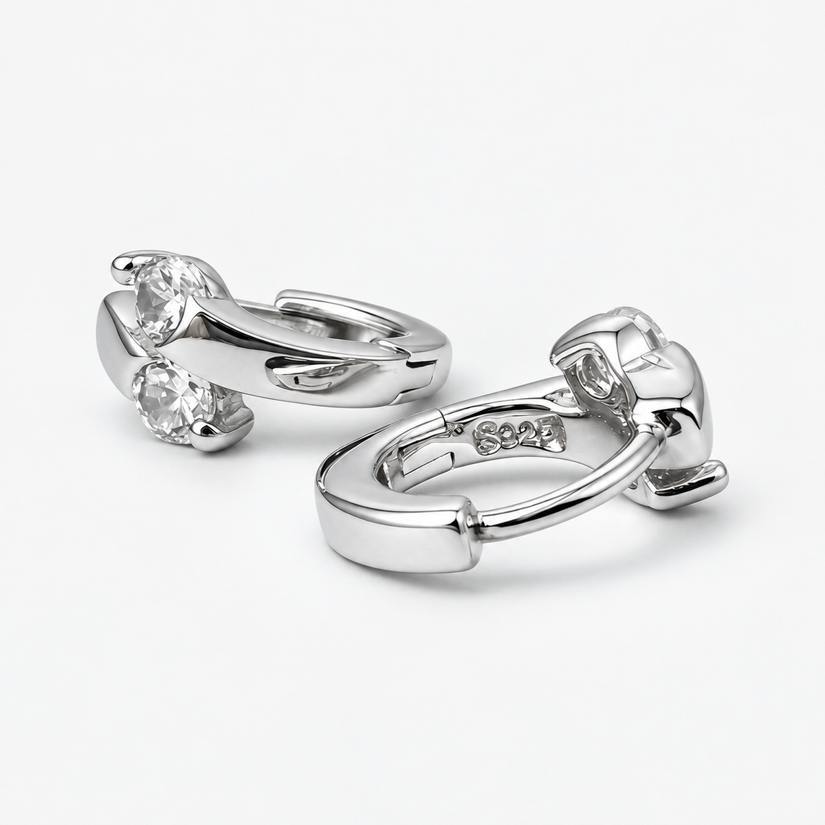 Silver Lumi double CZ huggie earrings on a white background