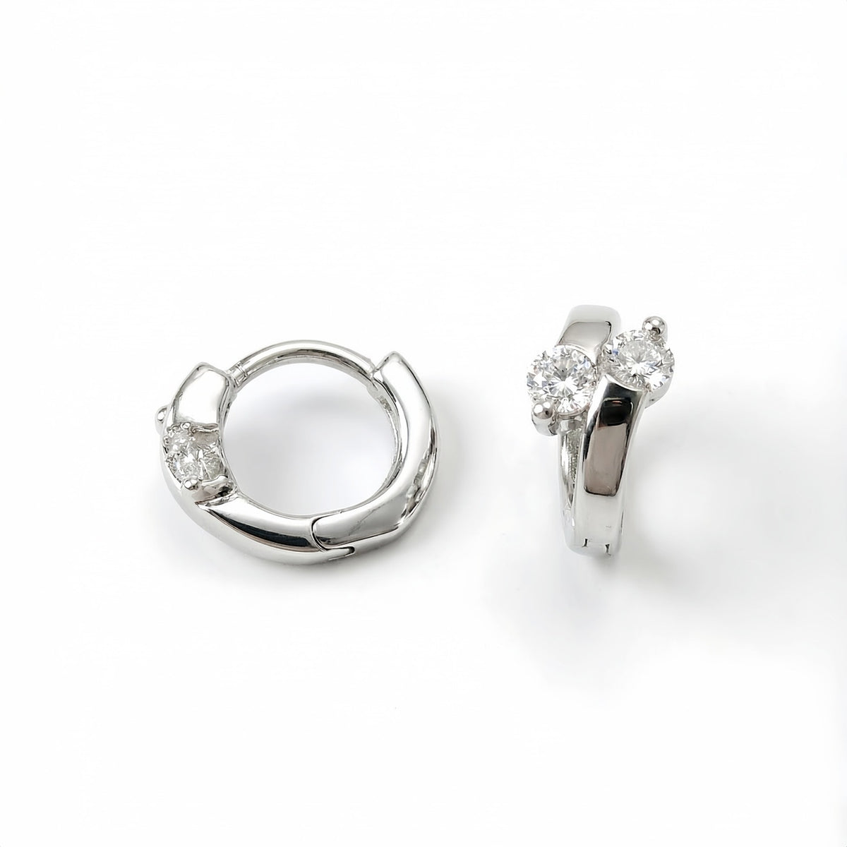 Silver Lumi double CZ huggie earrings on a white background