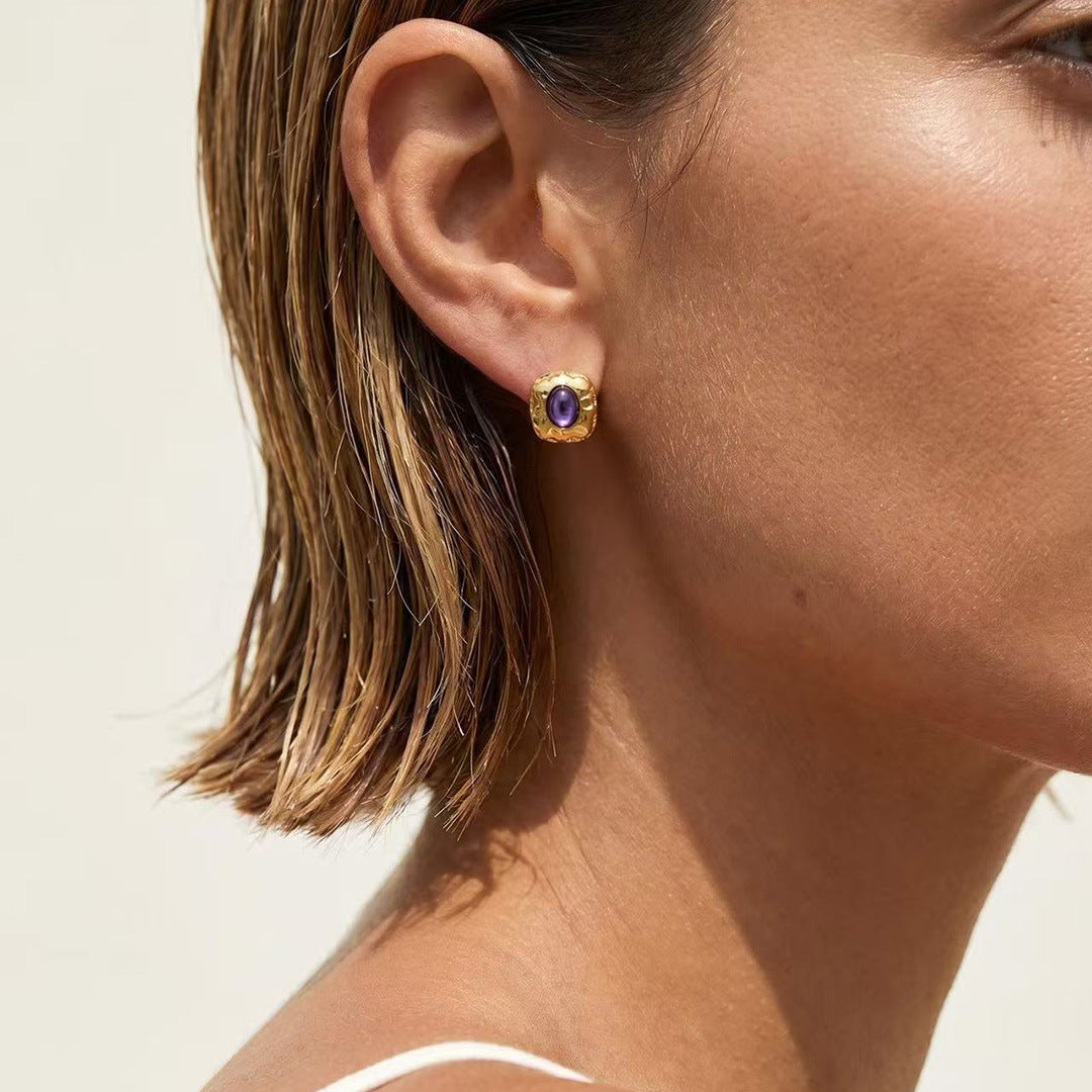 Close-up of natural charoite stones in sculptural gold-plated settings