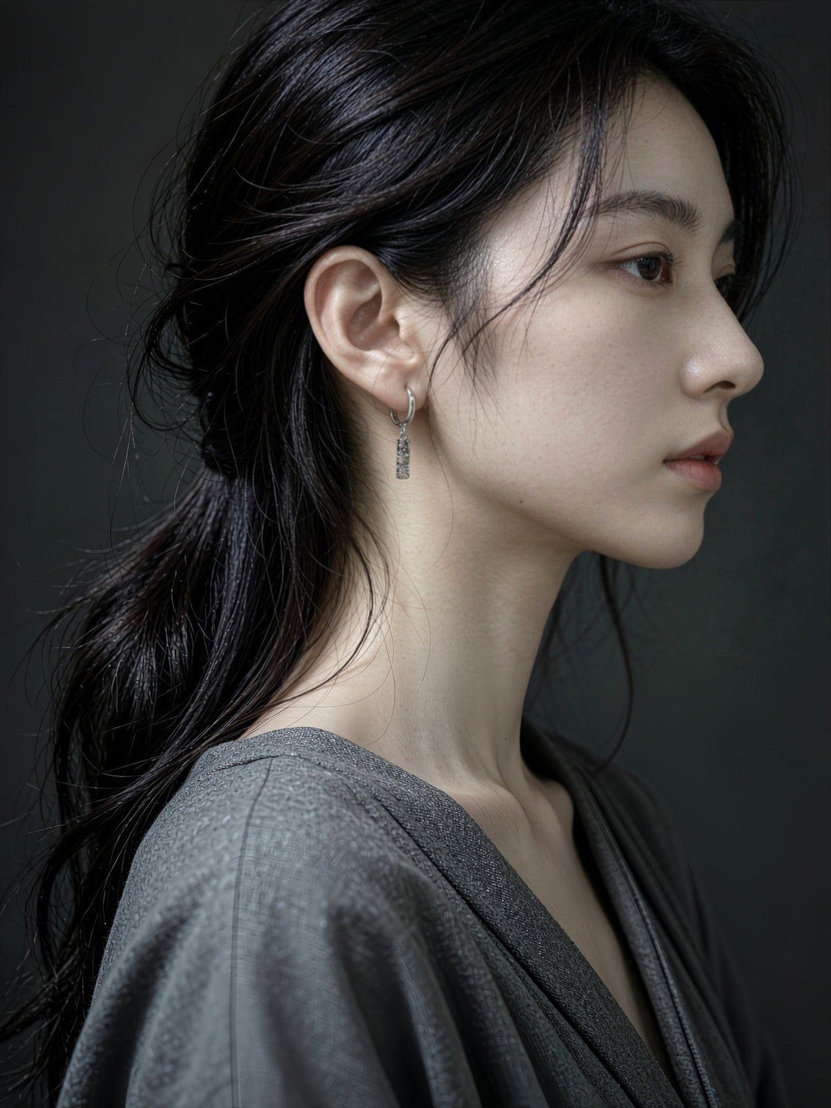 Model wearing a gold Sora hammered bar drop earring